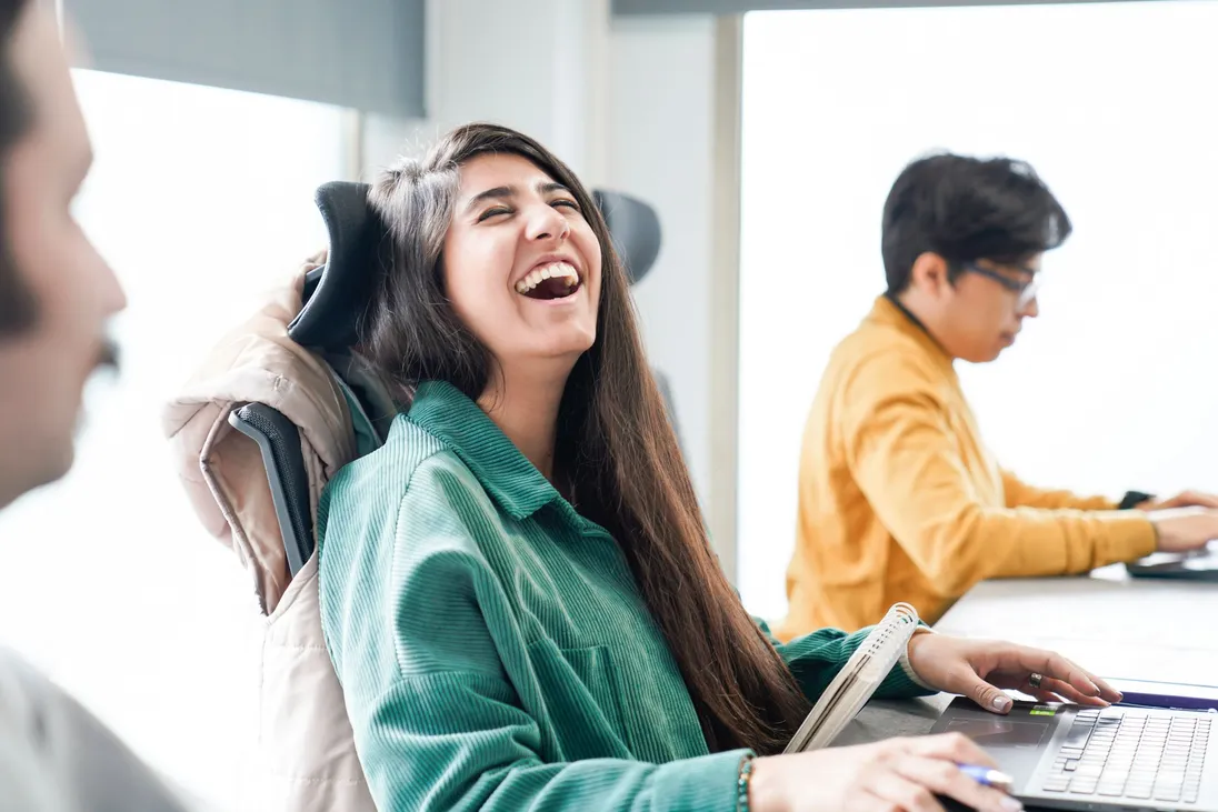 A SaaS founder laughing at her desk